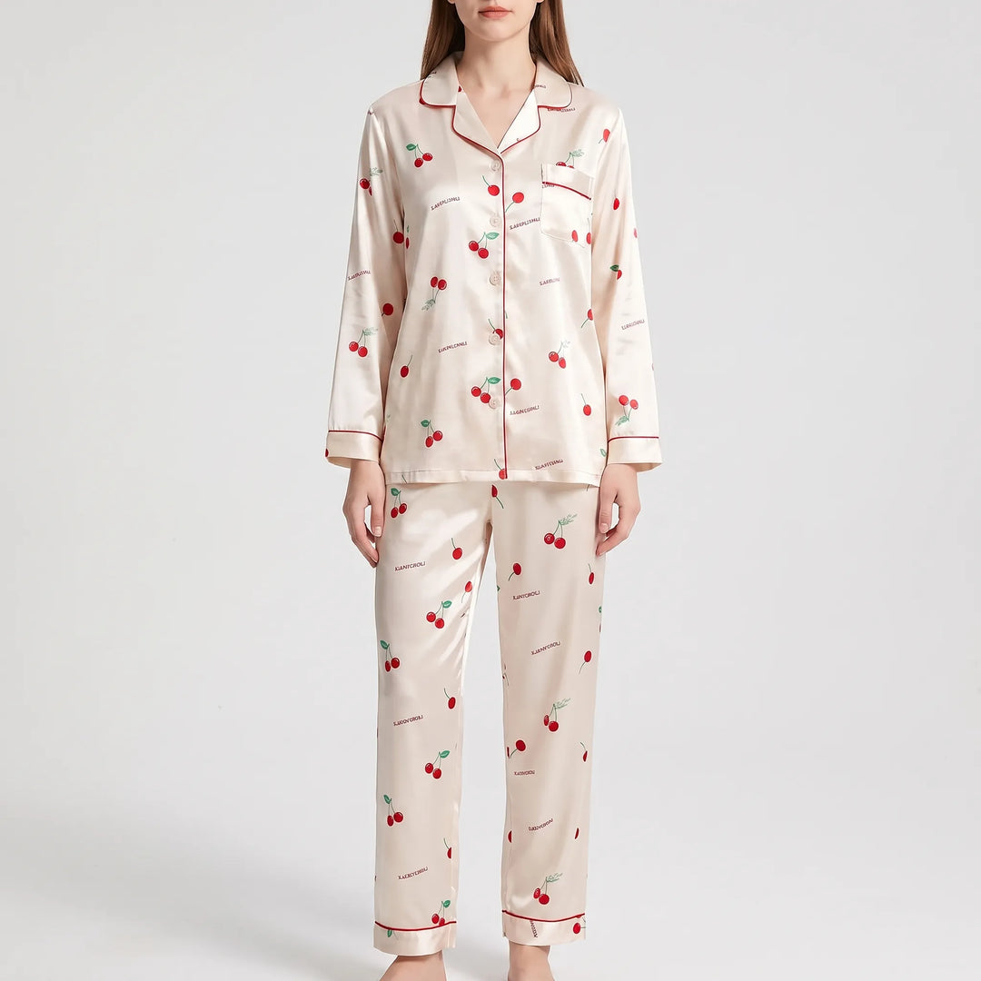 Model in a different pajama set: cream satin with red cherry print and red piping, shown from the front. 6