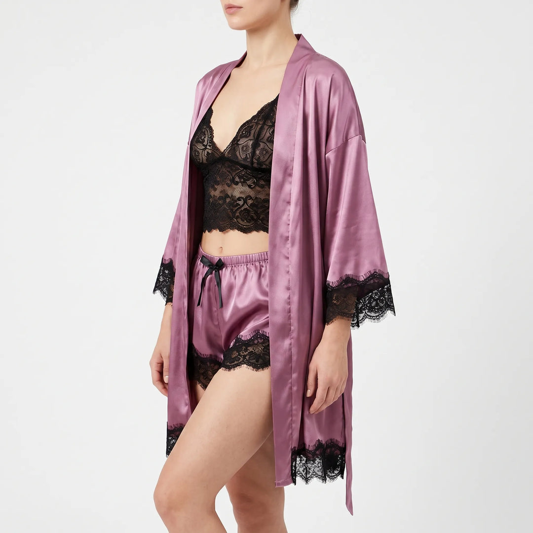 Side view of a model wearing the mauve satin robe open over a black lace bralette and matching satin shorts. 3