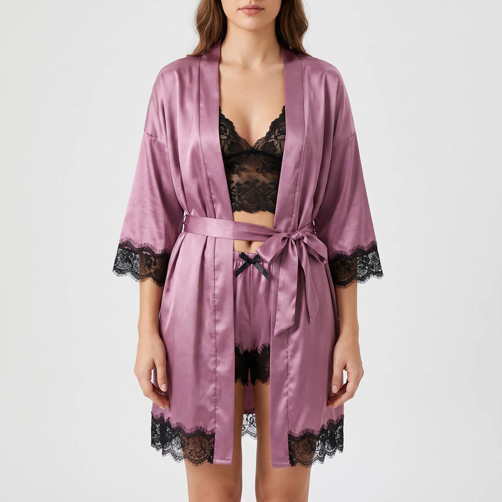 Front view of the mauve satin set with the robe belted in a bow over a black lace bralette and shorts. 6
