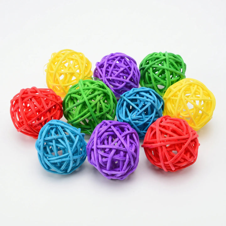 Ten woven rattan balls in yellow, purple, green, red and blue, piled together on a plain white background. 1