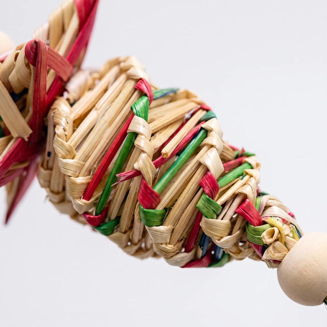 Close-up of the braided straw section woven with red, green and natural strands, next to a smooth wooden bead. 3