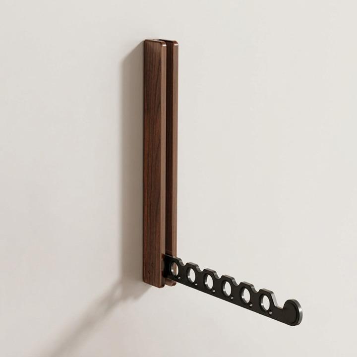 Foldable wooden wall coat rack detail with a black arm folded out at a right angle.