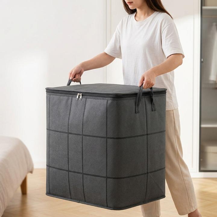 Grey geometric storage bag with two handles in a bedroom.