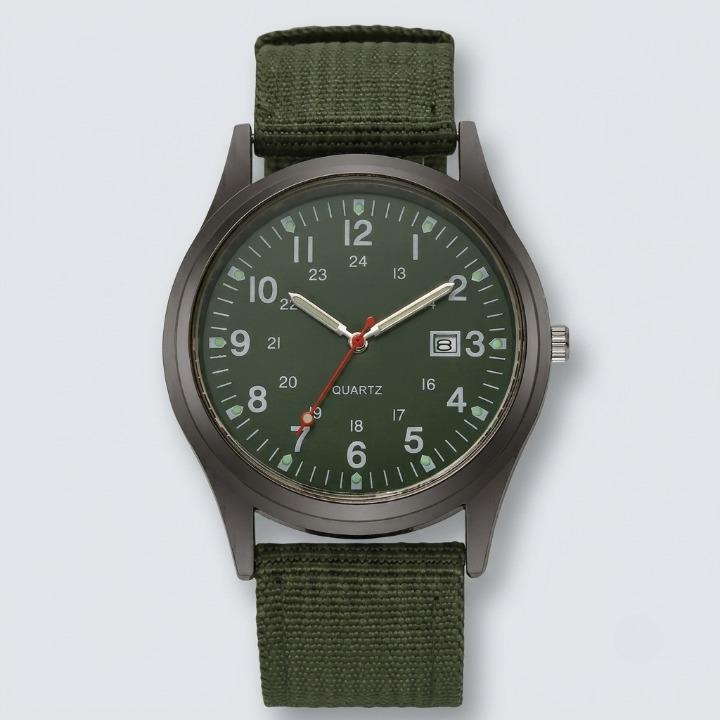 Green military watch with nylon strap, front view on a light background, showing the dark green dial and olive strap.