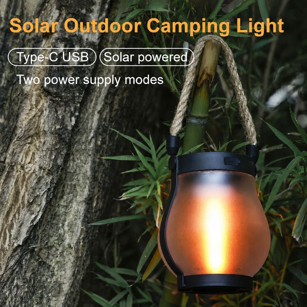 Black solar lantern hanging from a bamboo stalk beside a tree trunk, glowing warm orange, another view.