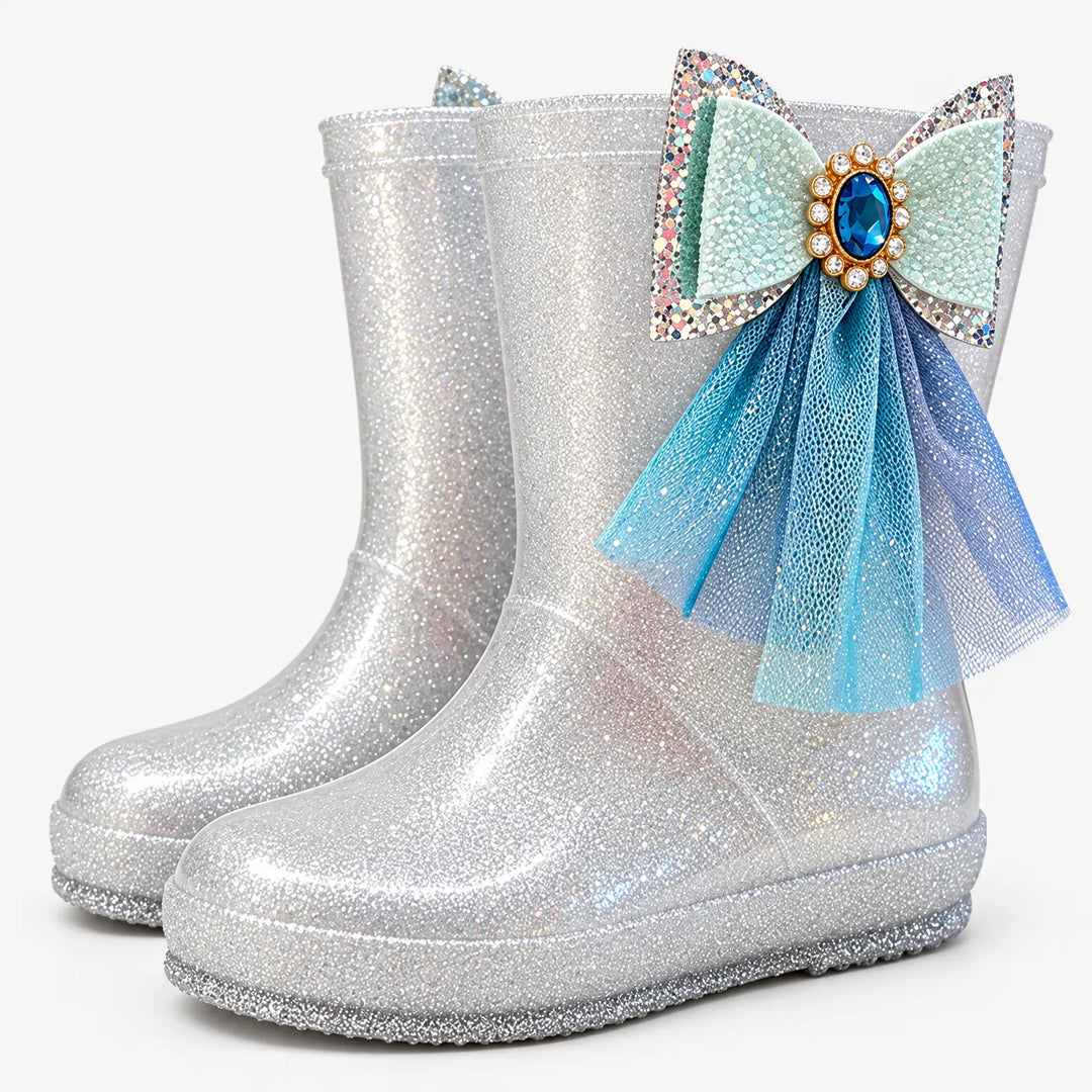 Pair of silver glitter rain boots at an angle, one with a mint bow, blue gem and blue tulle. 7