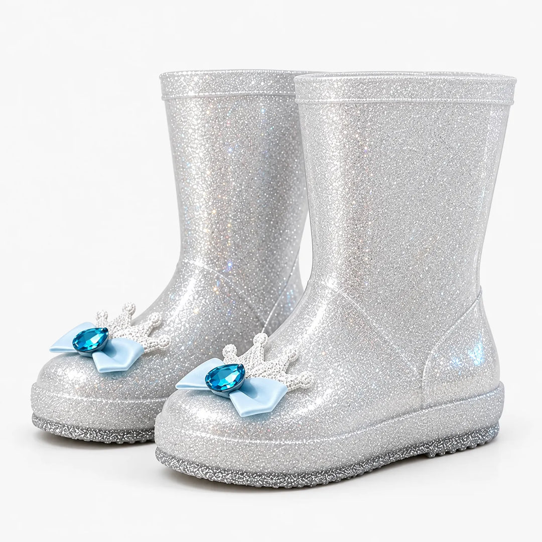 Pair of silver glitter rain boots at an angle, each toe decorated with a light blue bow, white crown and blue gem. 8