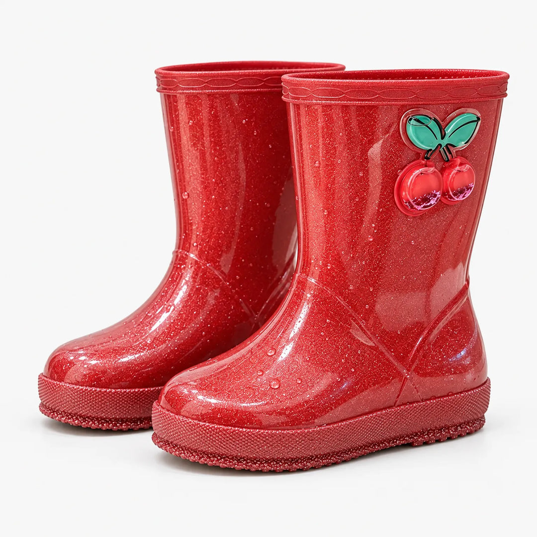 Pair of red glitter rain boots at an angle, dotted with water droplets, with a cherry charm on the right boot. 9
