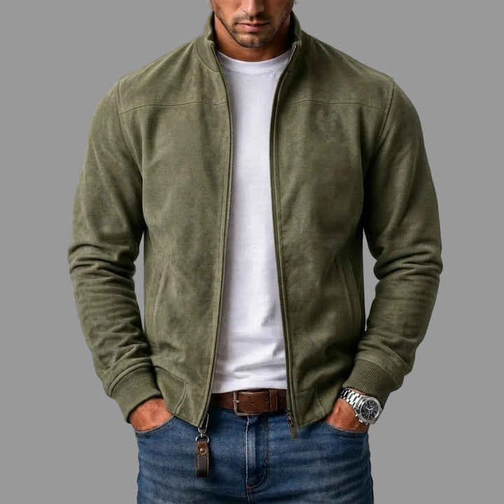 Olive green suede bomber worn unzipped by a model with a white tee, jeans and a leather zipper pull. 3