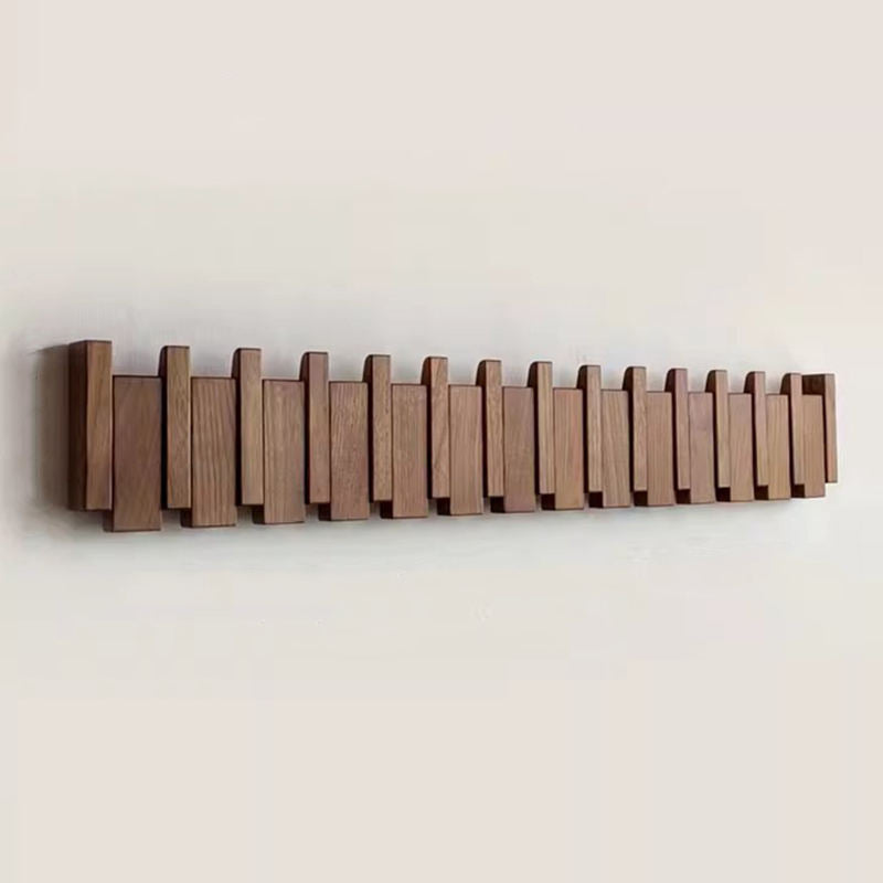 Long single-tone brown wood rack with many staggered slats, all hooks folded flat against a pale wall.