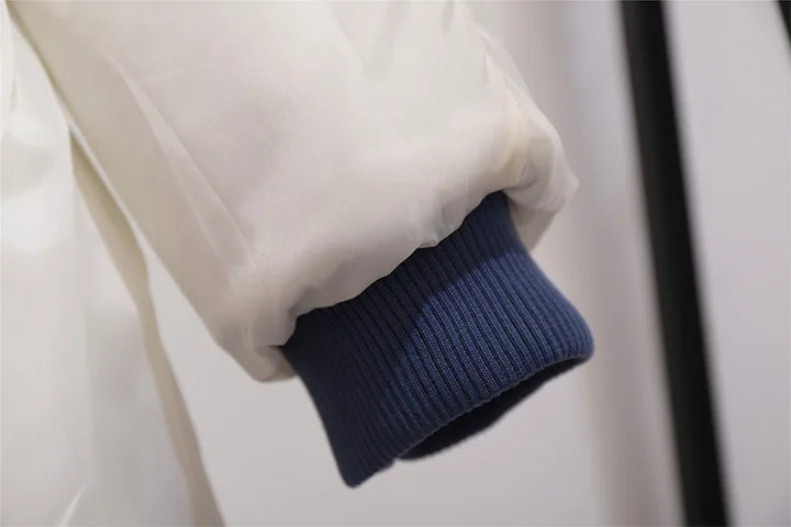 Weiße Daunenjacke mit blauem Bündchen, Wintermode, warm, stilvoll, hochwertig.