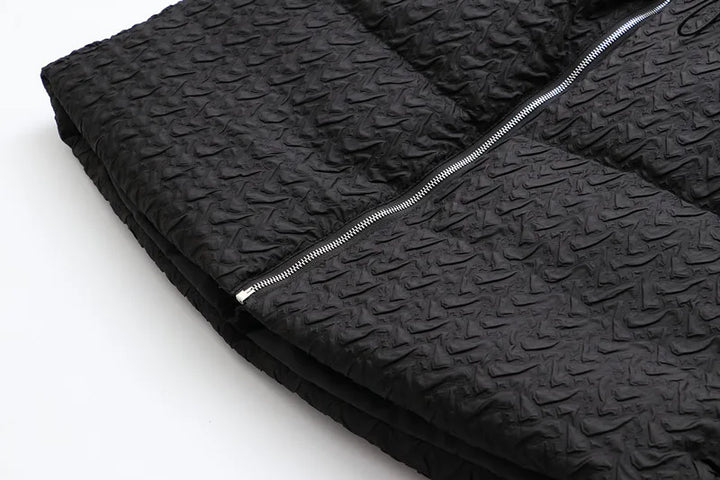 Schwarze gesteppte Jacke mit Reißverschluss, strukturierte Oberfläche, modisch, warm.