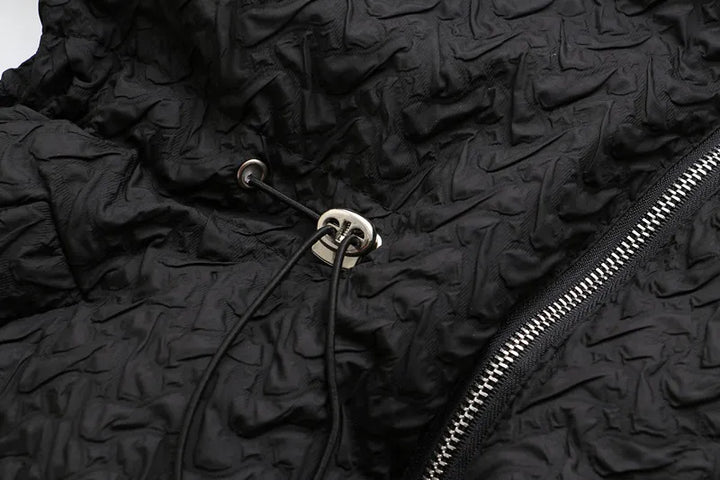 Schwarze Jacke mit Kordelzug, Reißverschluss, strukturierte Oberfläche, modisch, Unisex.