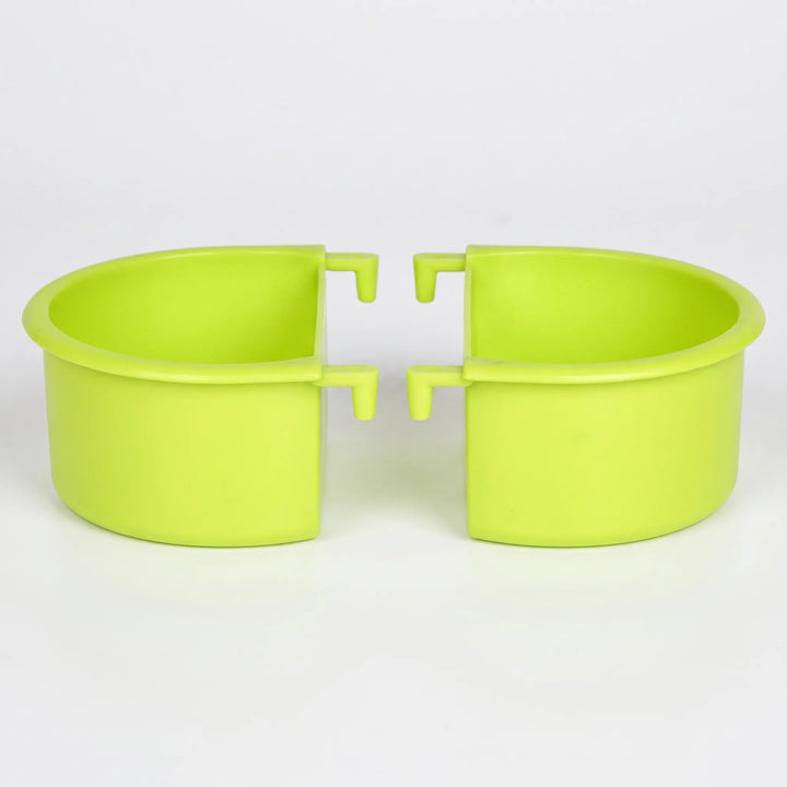 Two green plastic half-round bowls with hook tabs, set side by side with their open sides facing each other on a plain white background. 1