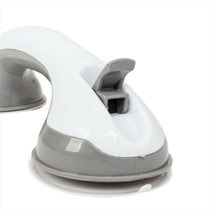 Close-up of the gray release tab lifted above the suction cup on the white and gray grab bar.