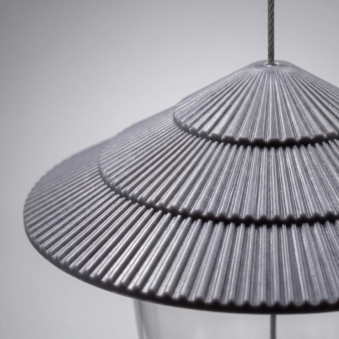 Close-up of the gray tiered roof showing its fine radial ribbing, with the hanging wire rising from the top. 3