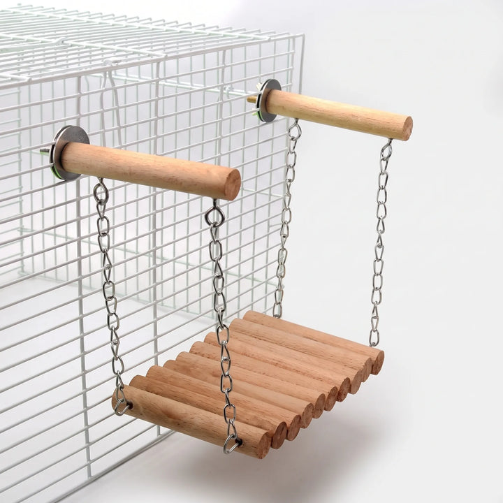 Natural wooden log swing hanging by chains from two perches attached to a white wire cage, shown in full. 5
