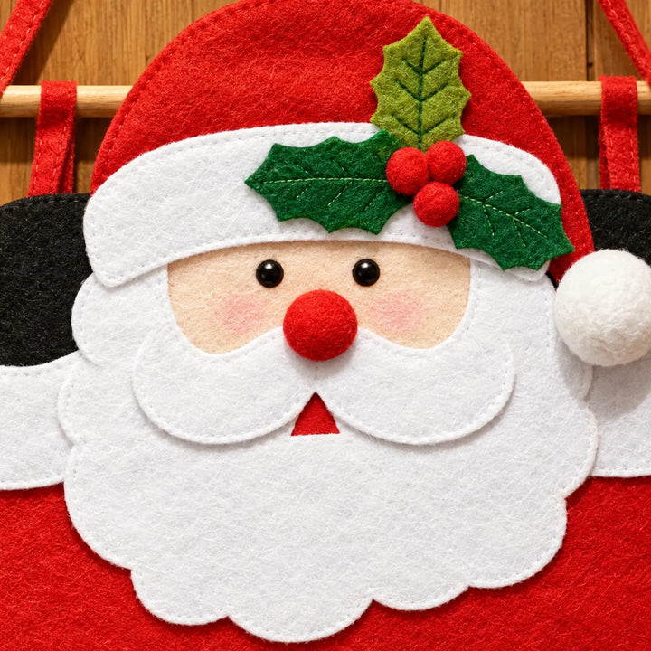 Close-up of Santa's face in stitched felt, showing a holly leaf and berries on his hat, red pom-pom nose and white beard. 3