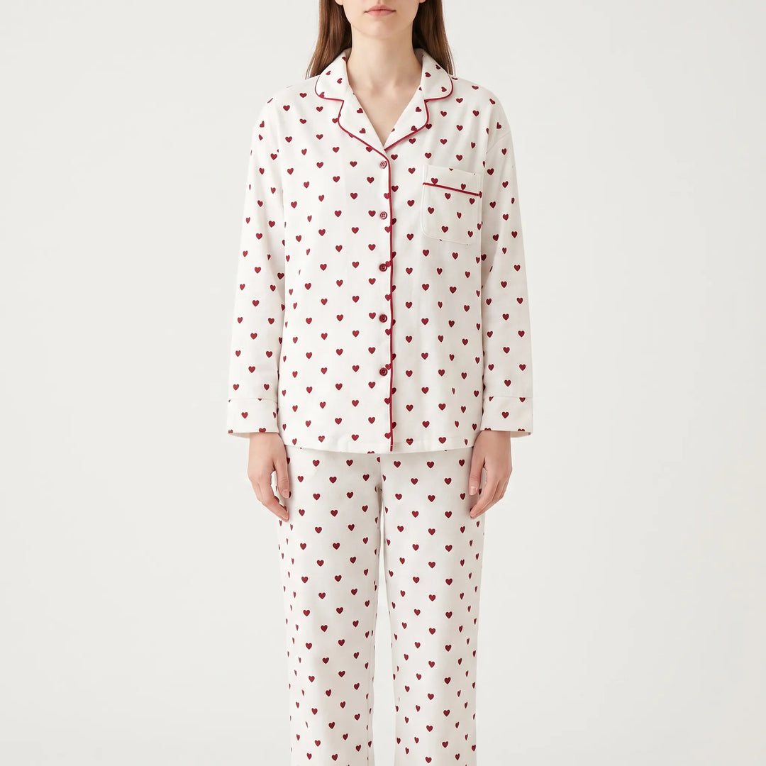 Model wearing the same pajama style in white with red hearts and red piping, front view on a plain background. 6