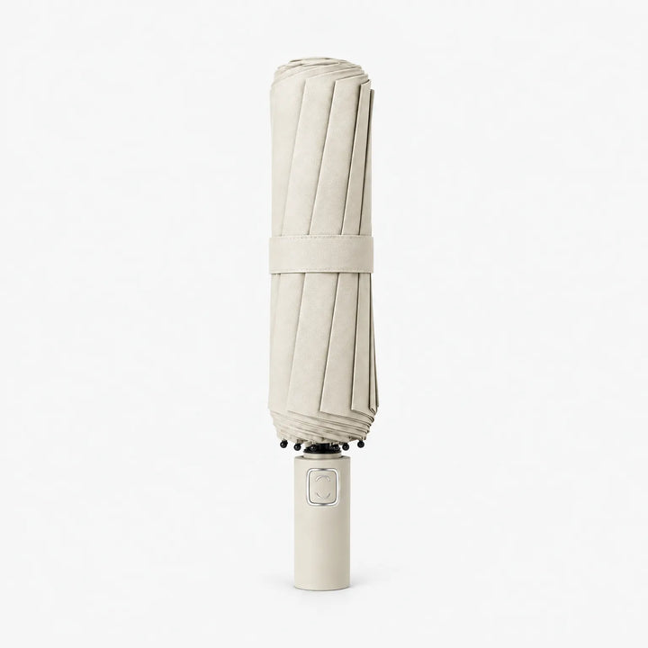 Folded cream umbrella with matching strap standing upright on its handle against a white background. 10