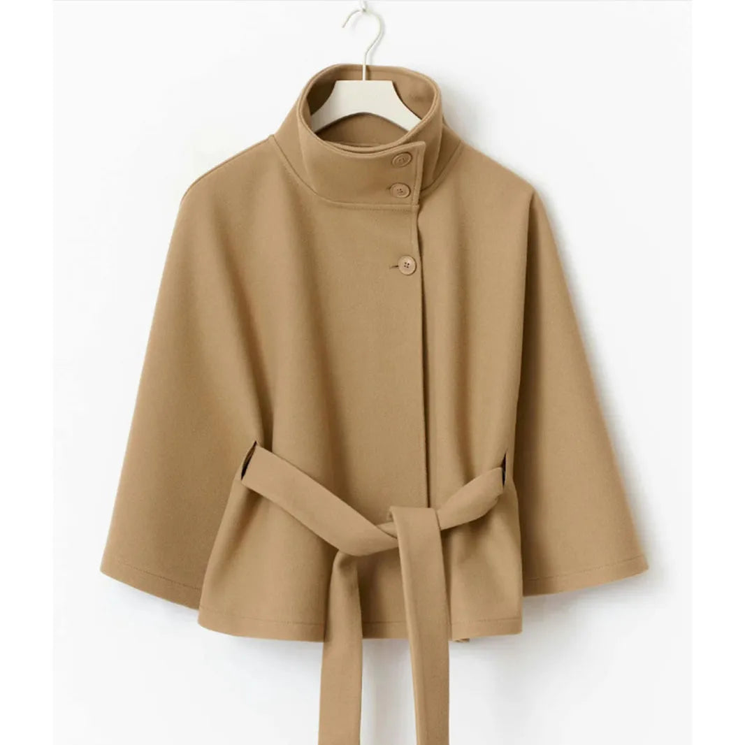 Camel cape jacket hanging on a hanger, showing the buttoned high collar and tied belt 7