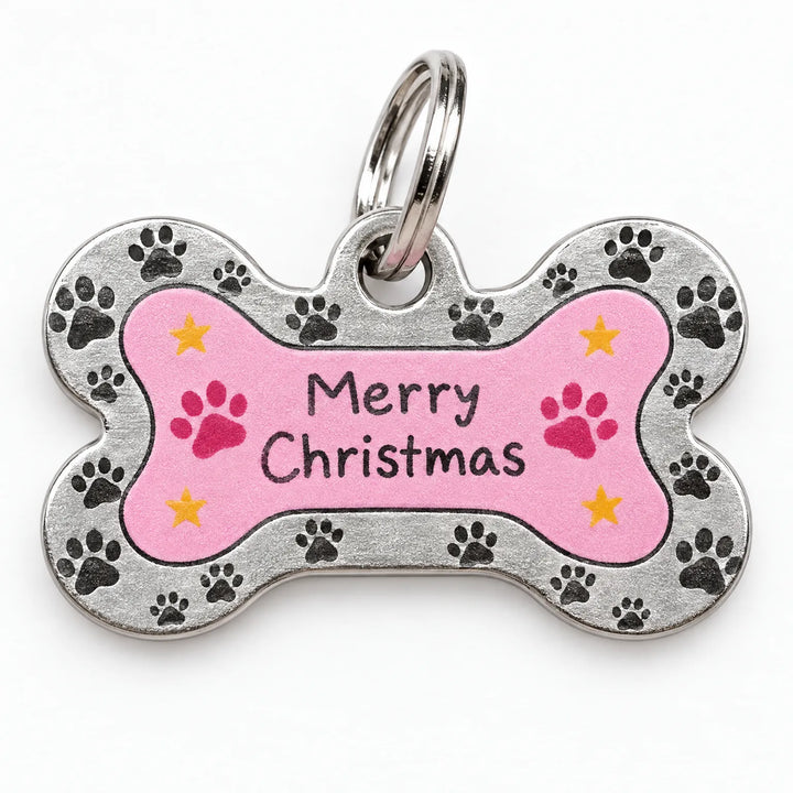 Close-up of a bone-shaped metal pet tag with a pink center, paw prints, yellow stars and a split ring. 3
