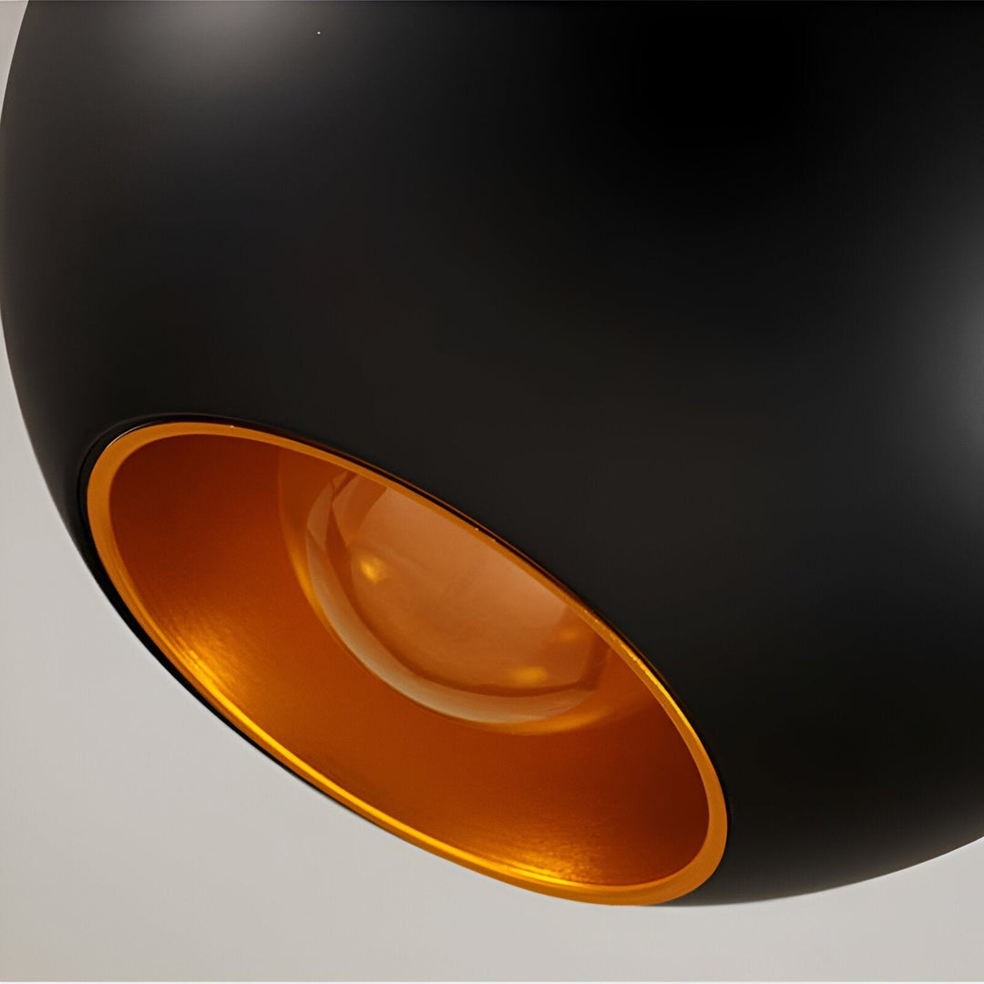AppleGlow Pendant Light detail of the black shell with the gold-lined opening and bulb.
