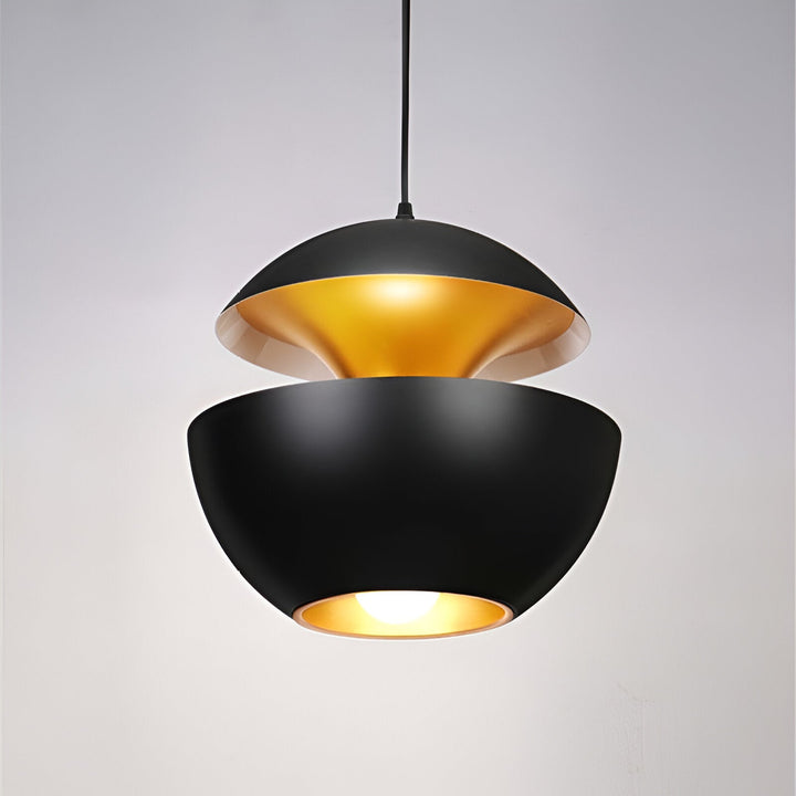 Black two-part apple-shaped pendant lamp with a gold-toned interior, hanging from a black cord with the bulb glowing below. 21