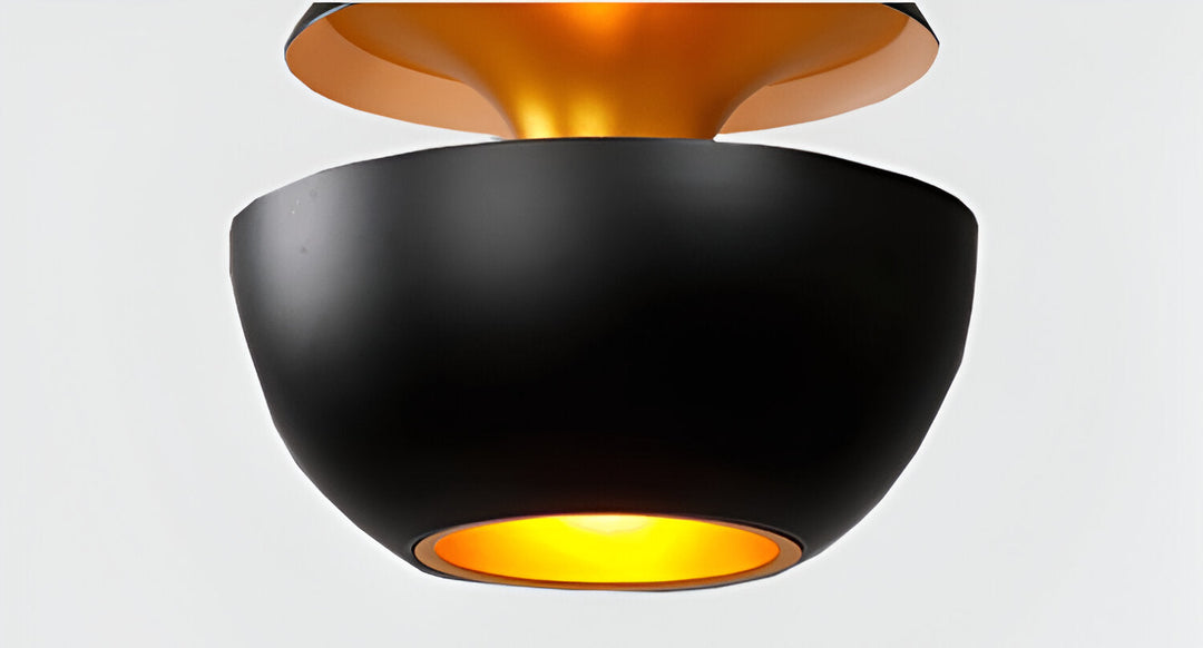 AppleGlow Pendant Light in black metal with a gold-lined upper cap and glowing lower bowl.