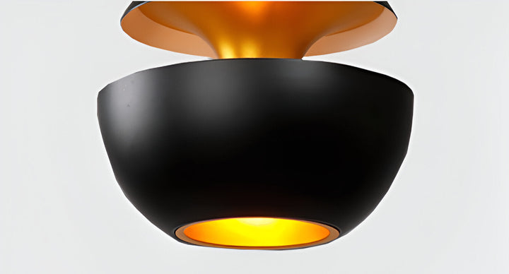 AppleGlow Pendant Light in black metal with a gold-lined upper cap and glowing lower bowl.
