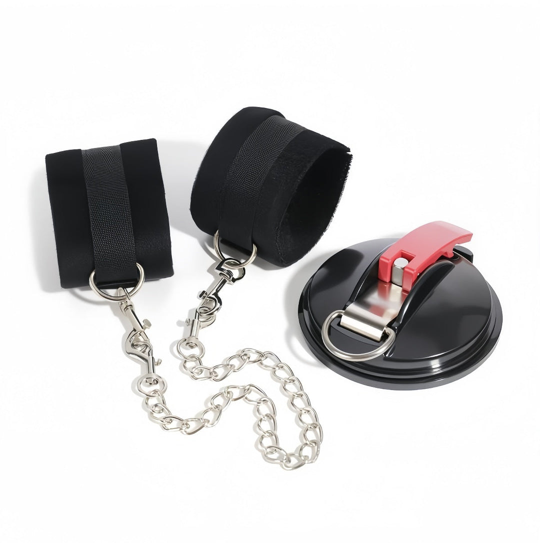 Pair of black padded fabric cuffs with metal rings joined by silver chains to a black suction mount with red lever. 5