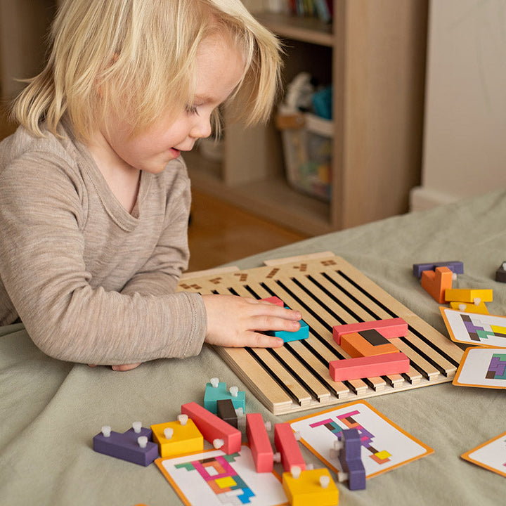 Wooden Tetris puzzle game another view with a toddler placing a block on the board