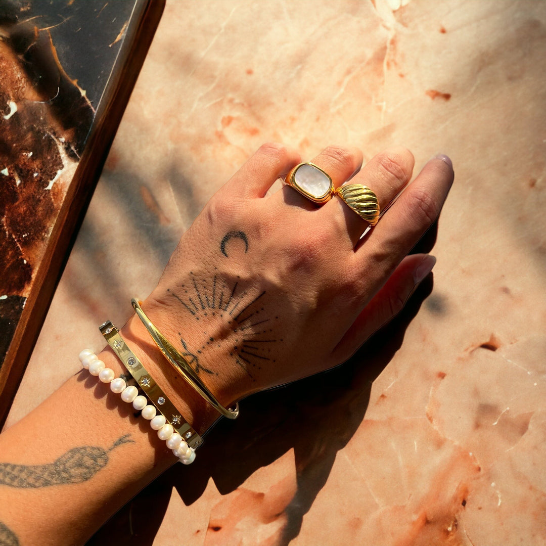 Lysa Gold Bracelet another view worn on a wrist with rings