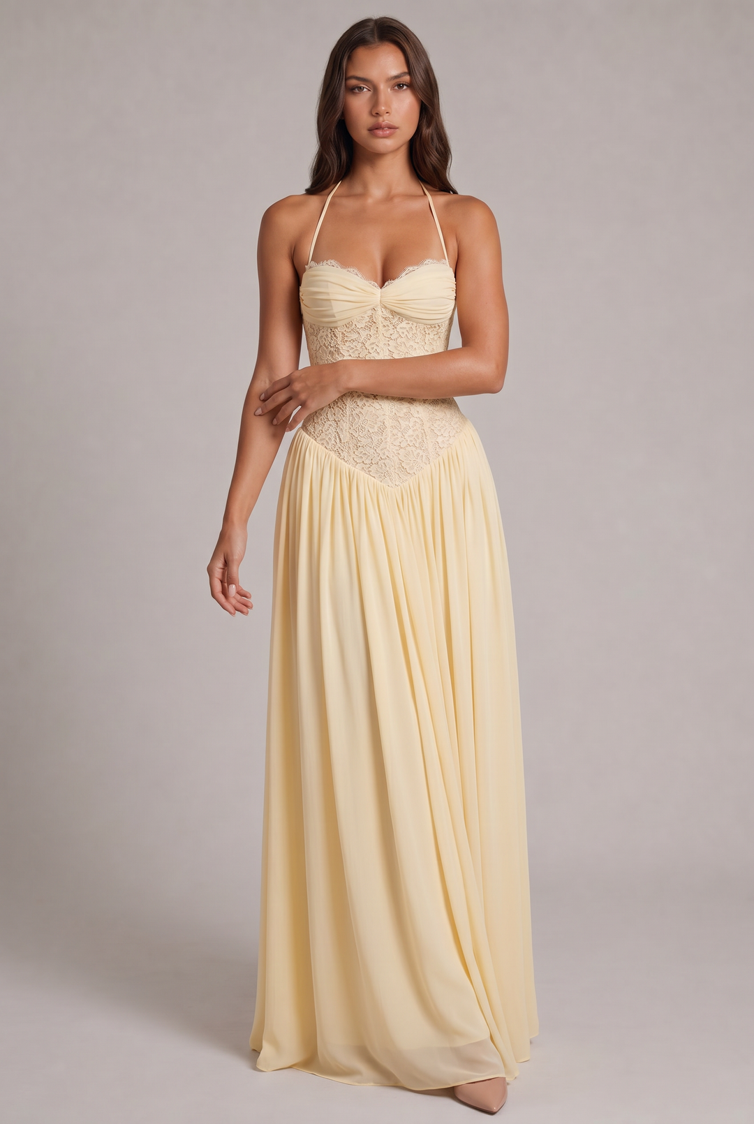 Model stands facing forward in the green version of the maxi dress, with lace bodice and straps.