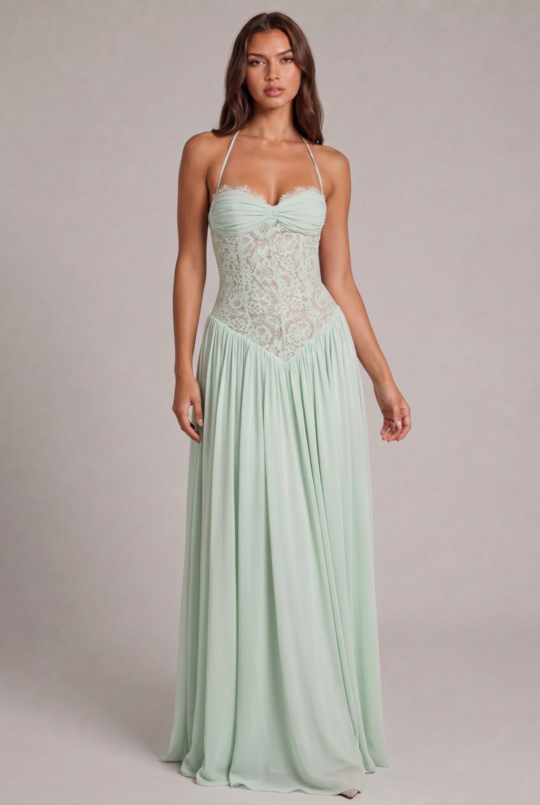Model faces forward in the green version of the maxi dress, with sheer lace bodice and flowing skirt.