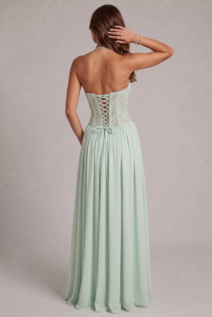 Back view detail of the green dress showing the criss-cross corset lacing, bow at the waist and open back.