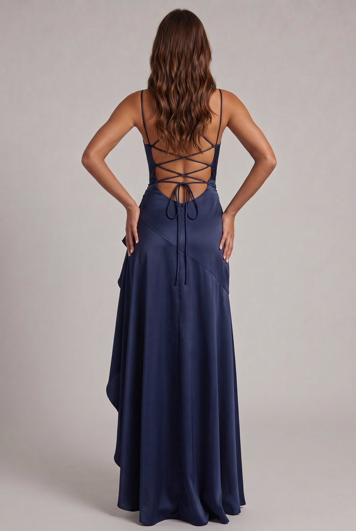 Back view of the navy satin dress showing crisscross lacing, tie closure and zipper, hands on hips 8