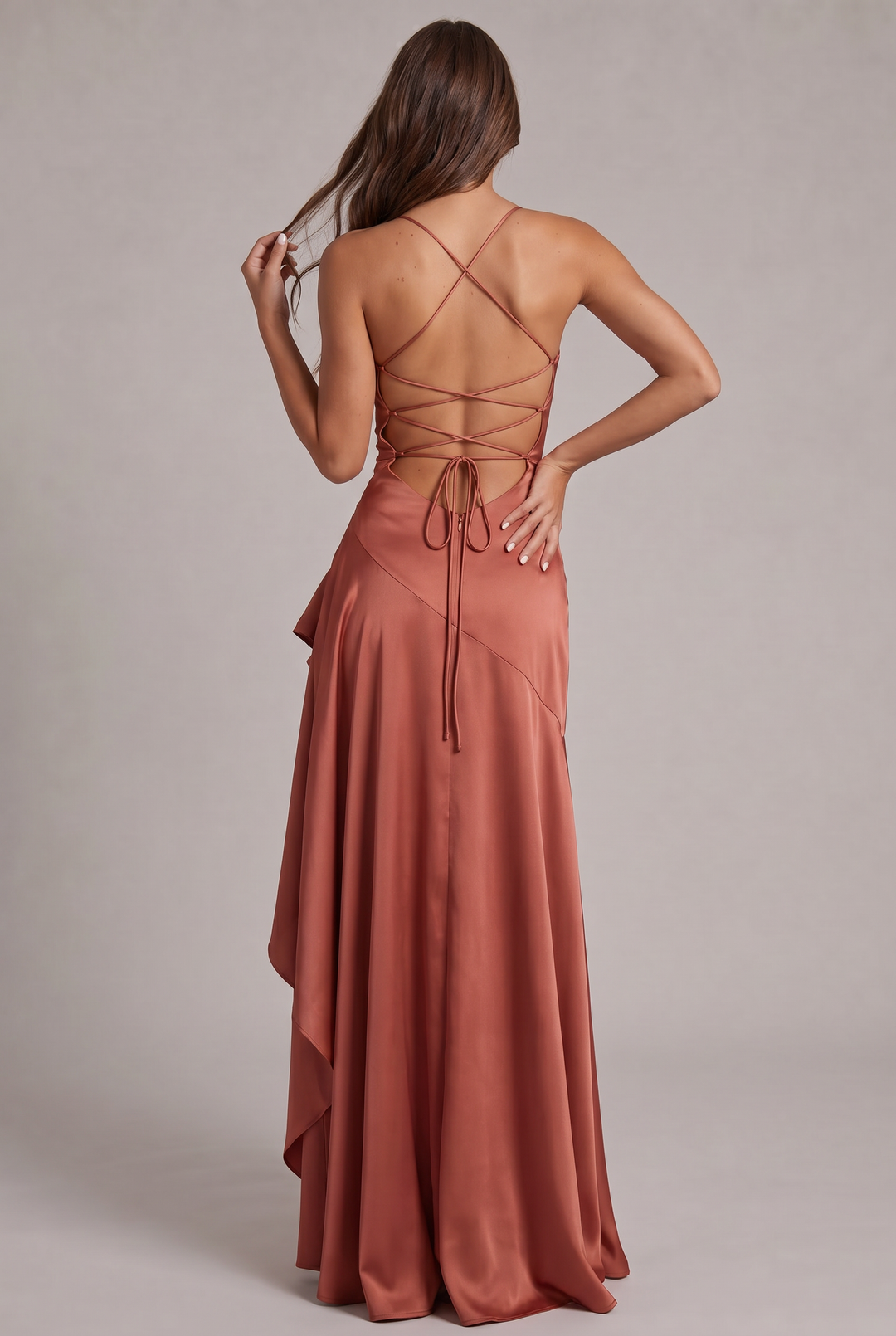 Back view of terracotta satin dress with lace-up crisscross straps and hair held in one hand 27