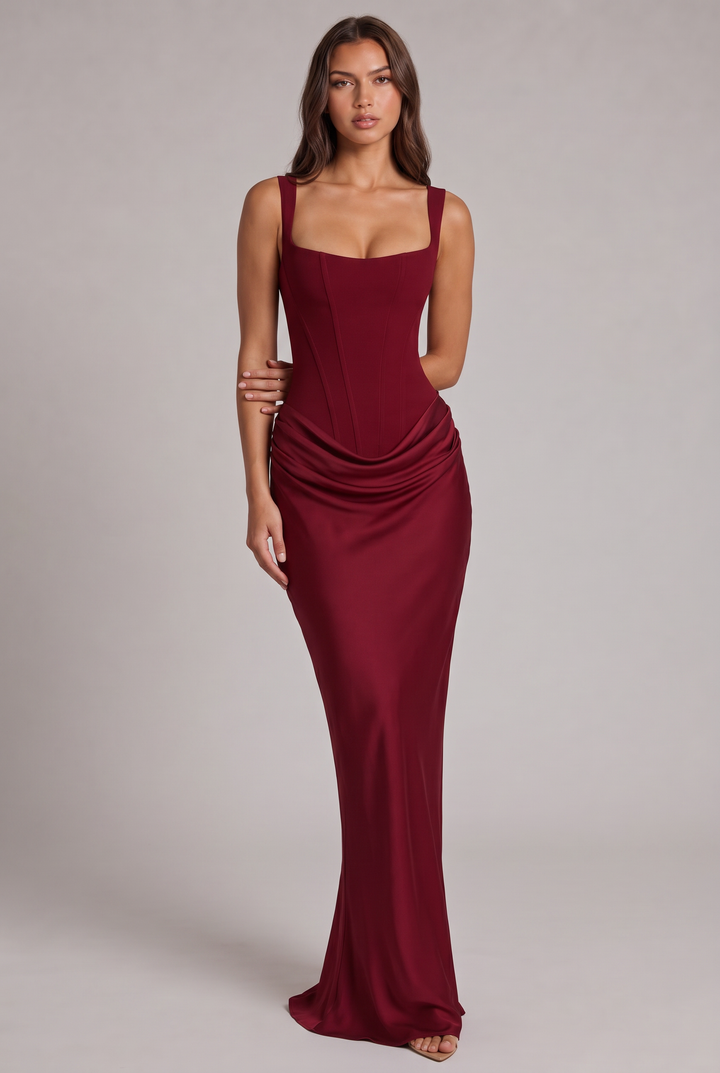 Full-length front view of the burgundy maxi dress with corset bodice, draped waist and long fitted skirt.