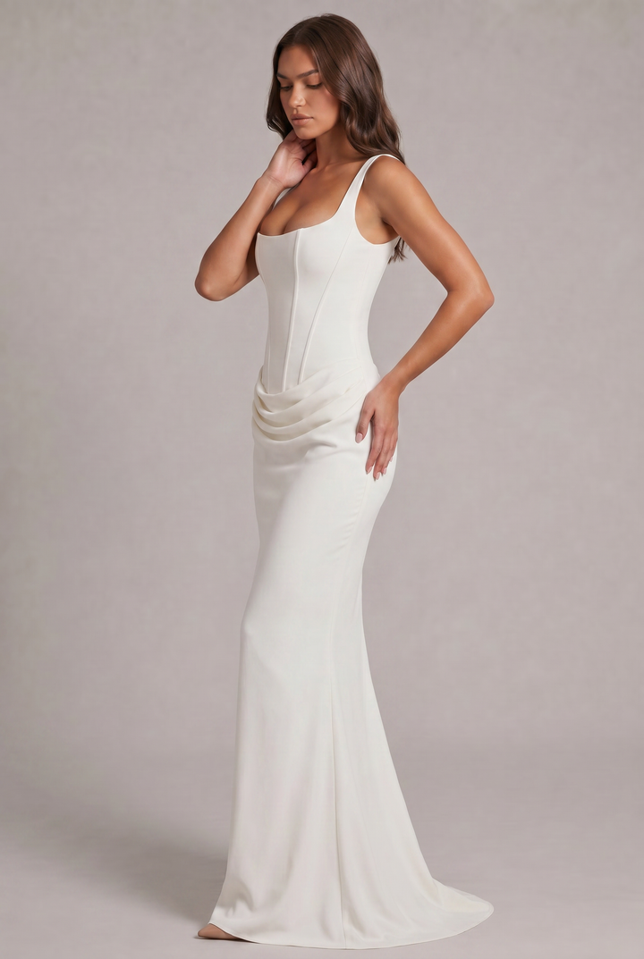 Another view of the white maxi dress showing the draped hip and the skirt flaring into a small train.