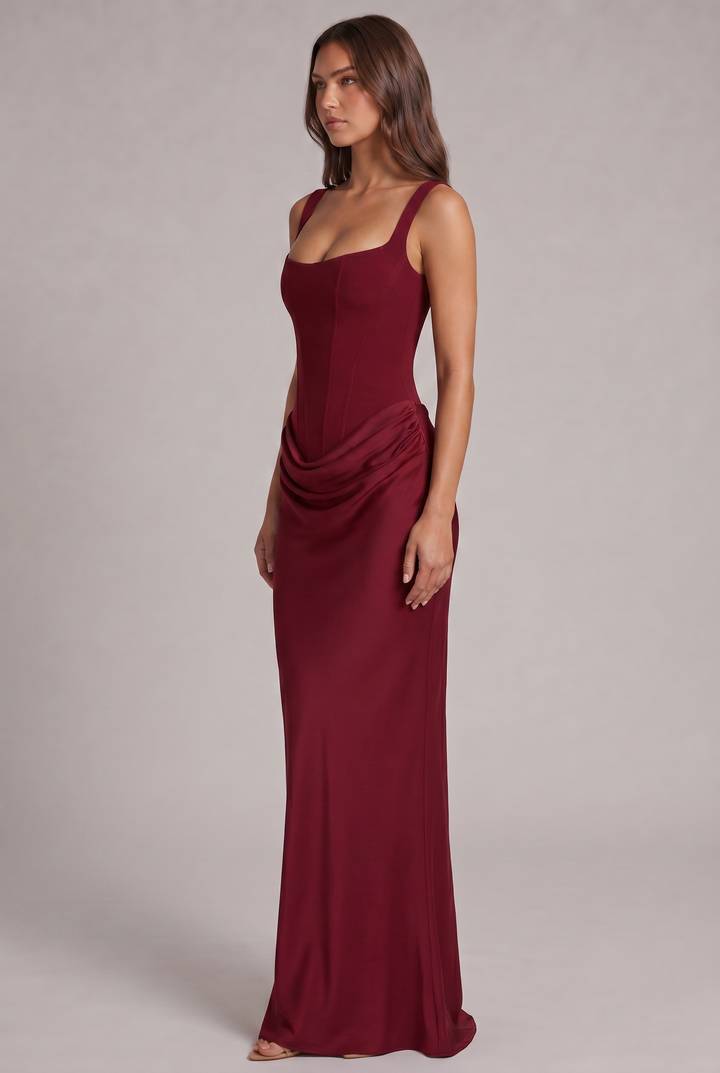 Another view of the burgundy maxi dress showing the draped hip and the fitted column skirt.