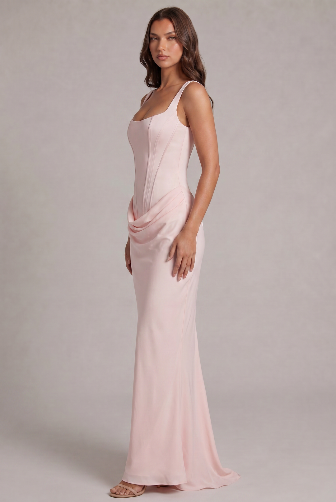 Side view of the light pink gown on a model, showing the fitted corset bodice, soft draping at the hip and flowing skirt with a train. 27