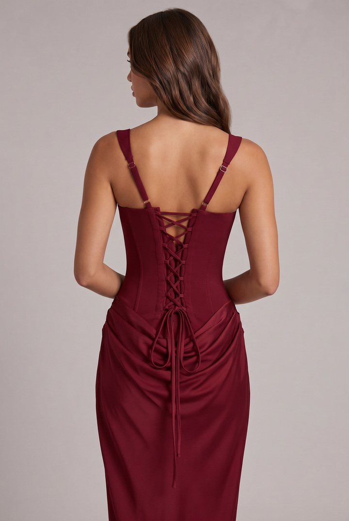 Detail of the burgundy dress showing the lace-up corset back, adjustable straps and long laces over the drape.