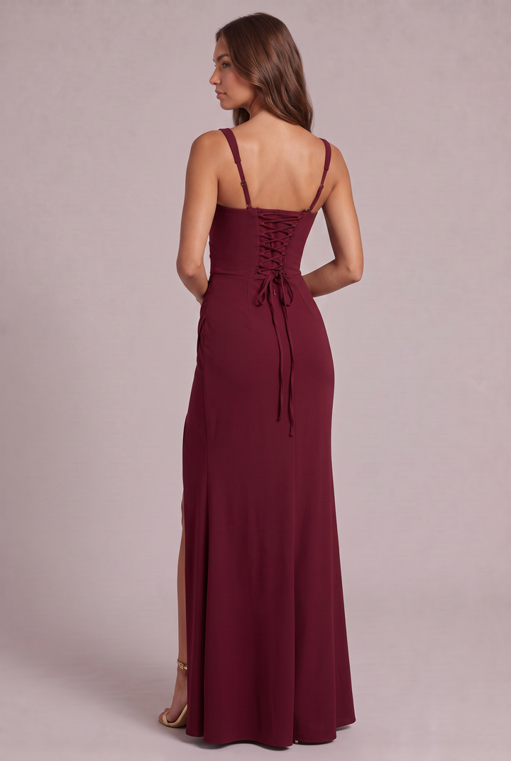 Back view of the burgundy dress on a model, showing the lace-up corset back with tie ends and adjustable straps. 12