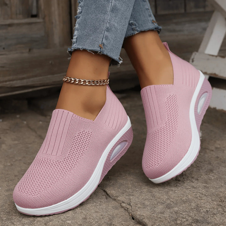 Pink knit slip-on sneakers with ribbed ankle panels and white air cushion soles, another view