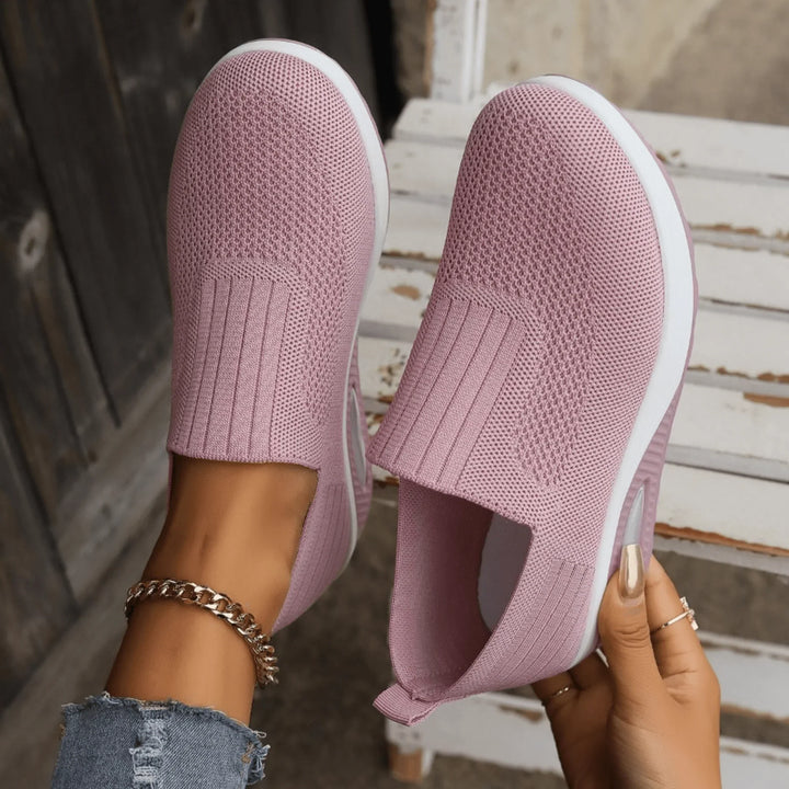 Top-down view of mauve pink knit slip-ons with a stretchy ribbed opening and mesh texture