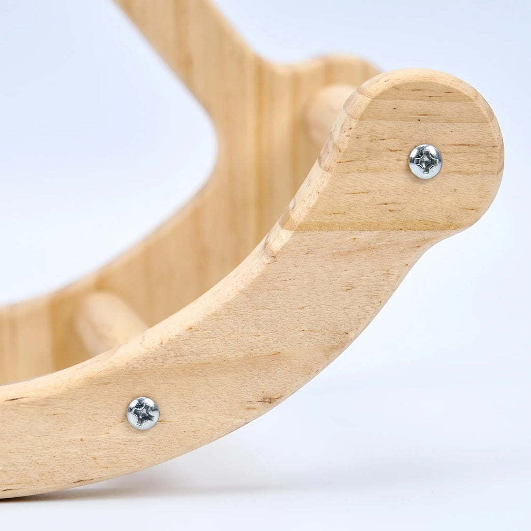 Close-up of the swing's curved wooden end piece, showing the light wood grain, metal screws and a dowel perch. 3