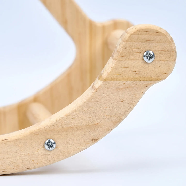 Close-up of the swing's curved wooden end piece, showing the light wood grain, metal screws and a dowel perch. 3
