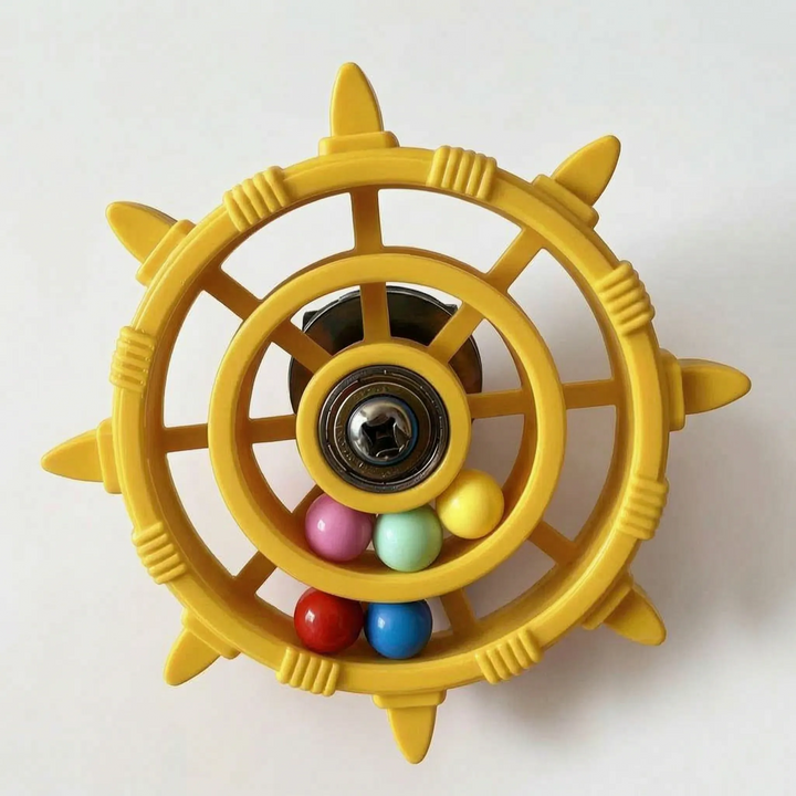 Yellow version of the wheel toy with a metal bearing hub and a few pastel, red and blue beads inside. 6