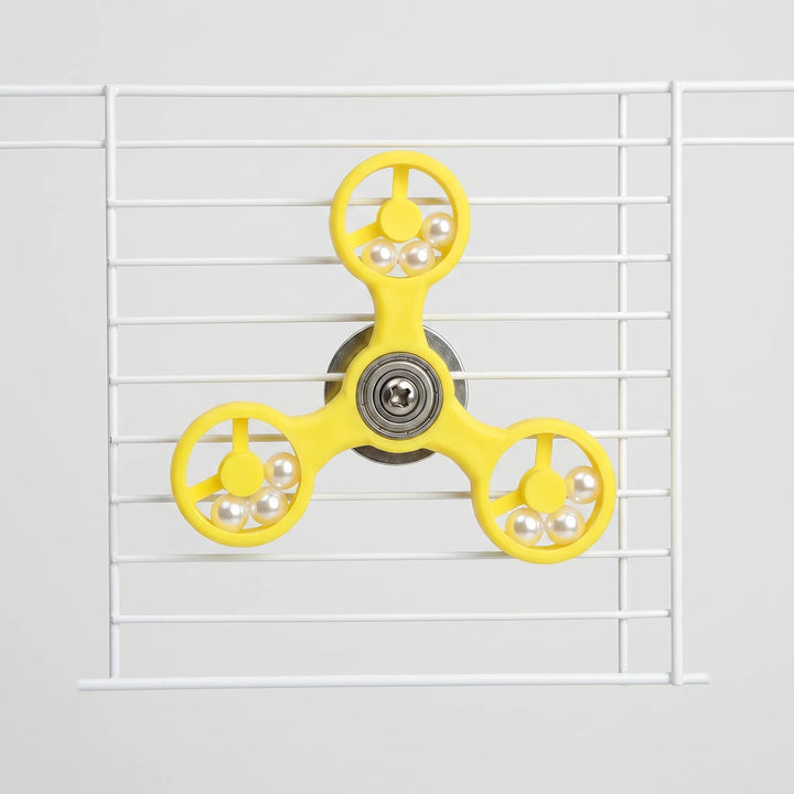 Front view of the yellow three-armed spinner with pearl beads in each ring, mounted on white cage wires. 1